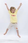 Young child wearing yellow t-shirt doing star jumps