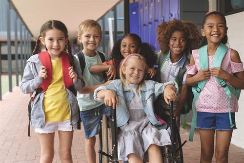 happy-diverse-school-kids-standing-in-outside-corridor-at-school